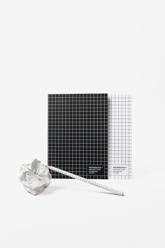 two grid sketchbooks - black and white - with paper ball and pencil