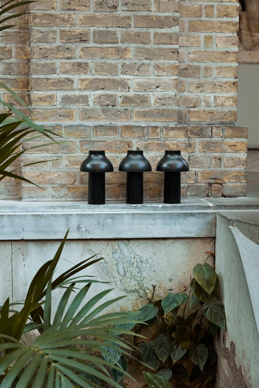 three black pc portable lamps on a brick fireplace