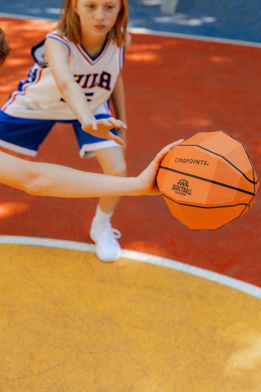 Enfant avec une maquette prédécoupé pour activité manuelle à la maison. Kit 3D pour enfants sur le basket